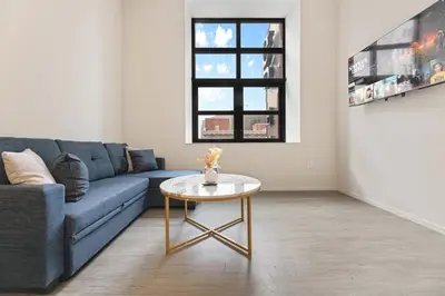 a living room with a blue couch and a table at Luxury DT Condo l Playhouse Square l Fast W-Fi in Cleveland