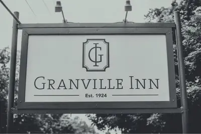 a sign for aennaulic inn with trees in the background at Granville Inn in Granville