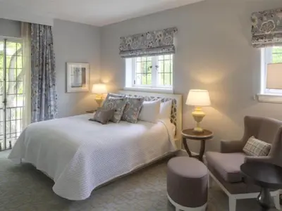 a bedroom with a bed and a chair and windows at Granville Inn in Granville