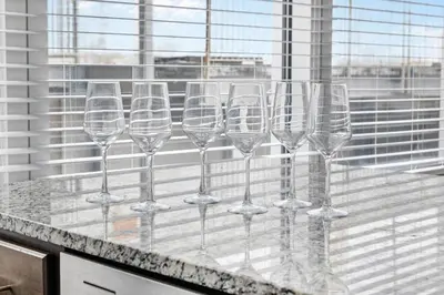 a row of wine glasses sitting on a counter at Near DT & CLE Clinic Queen Bed Wi-Fi Parking in Cleveland