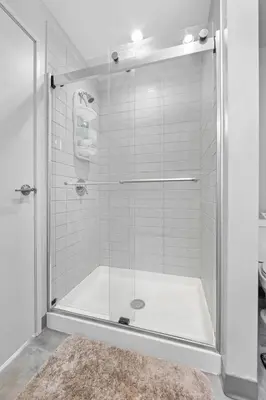 a shower with a glass door in a bathroom at Near DT & CLE Clinic Queen Bed Wi-Fi Parking in Cleveland