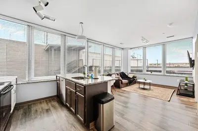a kitchen and living room with large windows at Near DT & CLE Clinic Queen Bed Wi-Fi Parking in Cleveland