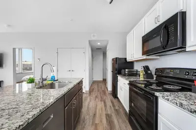 a kitchen with white cabinets and black appliances at Near DT & CLE Clinic Queen Bed Wi-Fi Parking in Cleveland