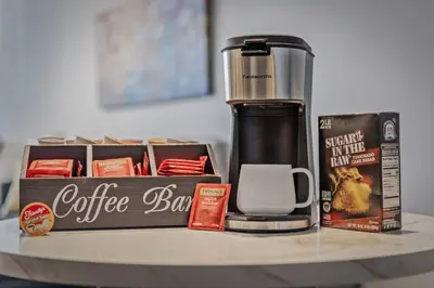 a coffeemaker sitting on a table next to a coffee bar at MDRN Escape with Natural Light Wi-Fi Gym Parking in Cleveland