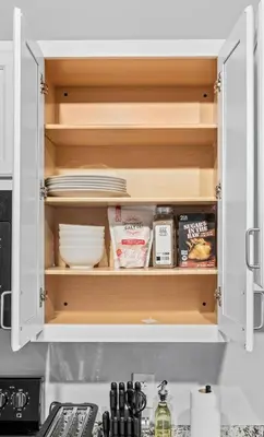a kitchen cabinet filled with plates and other items at MDRN Escape with Natural Light Wi-Fi Gym Parking in Cleveland