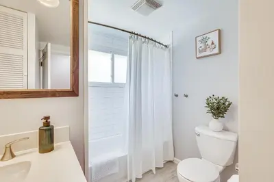 a white bathroom with a toilet and a mirror at Fish, Hike and Golf Leisurely Navarre Home with Yard! in Navarre