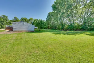 a large yard with a shed and trees at Fish, Hike and Golf Leisurely Navarre Home with Yard! in Navarre