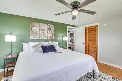 a bedroom with a white bed with a ceiling fan at Fish, Hike and Golf Leisurely Navarre Home with Yard! in Navarre