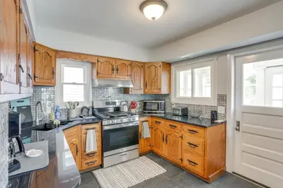 a kitchen with wooden cabinets and a stove top oven at Walk to Lake Erie Spacious Home in Sandusky! in Sandusky