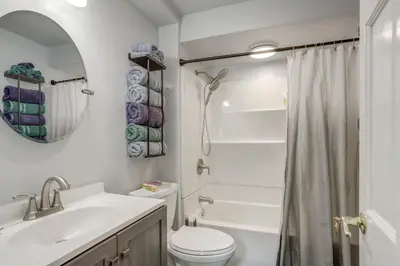 a bathroom with a sink toilet and a mirror at Walk to Lake Erie Spacious Home in Sandusky! in Sandusky