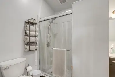 a white bathroom with a shower and a toilet at Walk to Lake Erie Spacious Home in Sandusky! in Sandusky
