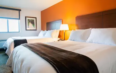 a hotel room with two beds and an orange wall at My Place Hotel-Pittsburgh North/Monaca, PA in Monaca