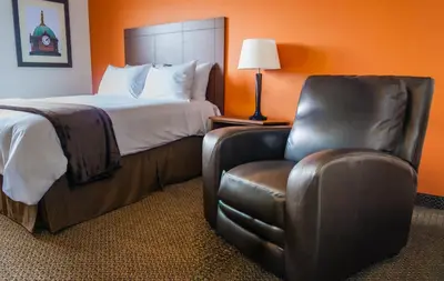 a bed and a chair in a hotel room at My Place Hotel-Pittsburgh North/Monaca, PA in Monaca