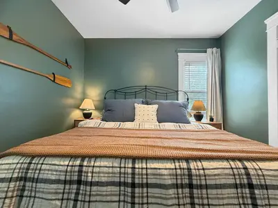 a bedroom with a large bed with blue walls at Chic Lakeside Retreat Steps from the Beach in Cleveland