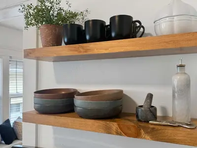 a shelf with bowls and vases on it at Chic Lakeside Retreat Steps from the Beach in Cleveland