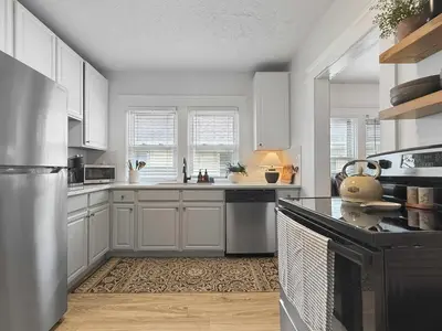 a kitchen with white cabinets and a counter top at Chic Lakeside Retreat Steps from the Beach in Cleveland