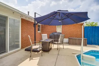 a blue umbrella sitting on a patio next to a pool at Dayton Family Home with Game Room Walk to City Park in Dayton