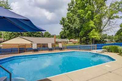 a swimming pool with chairs and an umbrella at Dayton Family Home with Game Room Walk to City Park in Dayton