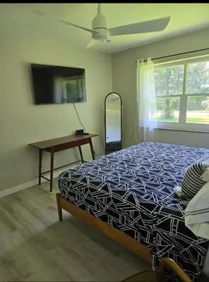 a bedroom with a bed and a desk and a window at MidCity Country Charm in Cincinnati