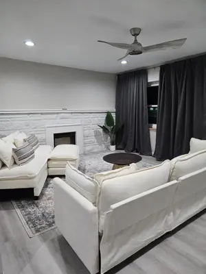a living room with white furniture and a fireplace at MidCity Country Charm in Cincinnati