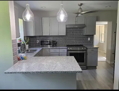 a kitchen with white cabinets and a counter top at MidCity Country Charm in Cincinnati
