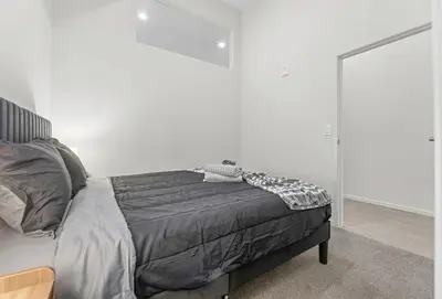 a bed in a bedroom with a white wall at Luxury Condo l DT l Playhouse Square l Sofa Bed in Cleveland