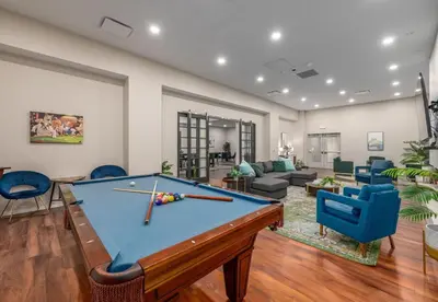 a living room with a pool table and blue chairs at Luxury Condo l DT l Playhouse Square l Sofa Bed in Cleveland