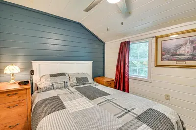 a bedroom with a bed and a window at 14 Mi to Kentucky Horse Park Creekside Cabin in Georgetown
