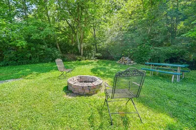 two chairs and a fire pit in a yard at 14 Mi to Kentucky Horse Park Creekside Cabin in Georgetown