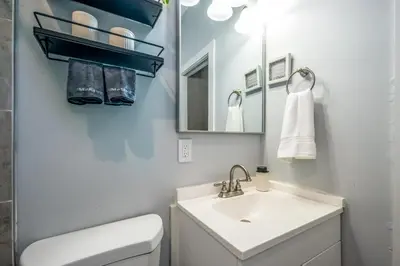 a white bathroom with a sink and a mirror at OTR 2 Lux Queen Beds Sleeps 5ppl Light Rail Wifi in Cincinnati