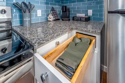an open drawer in a kitchen with blue tiles at OTR 2 Lux Queen Beds Sleeps 5ppl Light Rail Wifi in Cincinnati