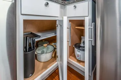 a kitchen with white cabinets and a pantry with utensils at OTR 2 Lux Queen Beds Sleeps 5ppl Light Rail Wifi in Cincinnati