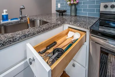 a kitchen drawer filled with cooking utensils next to a sink at OTR 2 Lux Queen Beds Sleeps 5ppl Light Rail Wifi in Cincinnati
