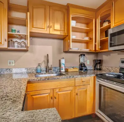 a kitchen with wooden cabinets and granite counter tops at 1Br in Heart of Downtown, Sauna, Prime Location in Cleveland