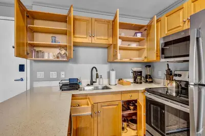 a kitchen with wooden cabinets and stainless steel appliances at 1BR Loft Sauna & Walk to Theater & Campus in Cleveland