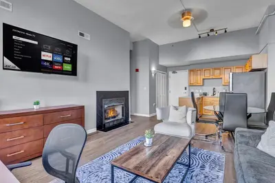 a living room with a table and a fireplace at 1BR Loft Sauna & Walk to Theater & Campus in Cleveland