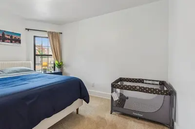 a bedroom with a bed and a tv in it at Luxury Olivewood Oasis - 13 mins to Cleveland in Lakewood