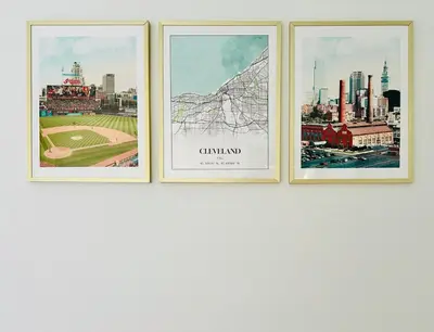 three framed pictures on a wall with a city at Luxury Olivewood Oasis - 13 mins to Cleveland in Lakewood