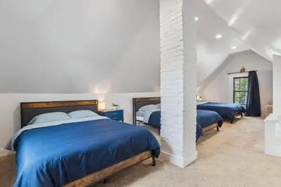 a bedroom with two beds with blue sheets at Luxury Olivewood Oasis - 13 mins to Cleveland in Lakewood