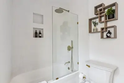 a white bathroom with a shower and a toilet at Luxury Olivewood Oasis - 13 mins to Cleveland in Lakewood