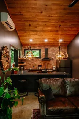 a living room with a couch and a kitchen at Whiskey Lounge in Loudonville