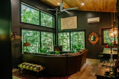 a living room with a large couch in a room with windows at Whiskey Lounge in Loudonville