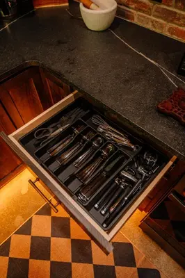 a kitchen counter with an open drawer with utensils at Whiskey Lounge in Loudonville