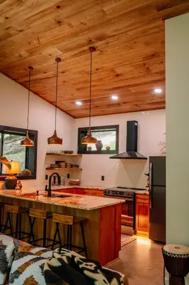 a kitchen with wooden ceilings and a large island at Native Legacy in Loudonville