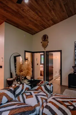 a bedroom with a bed and a large mirror at Native Legacy in Loudonville