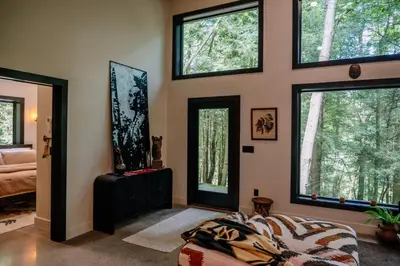 a bedroom with windows and a bed in a room at Native Legacy in Loudonville