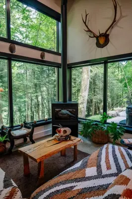 a living room with a coffee table and large windows at Native Legacy in Loudonville