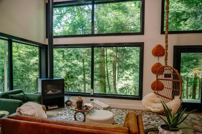 a living room with large windows and a couch at Lotus in Loudonville