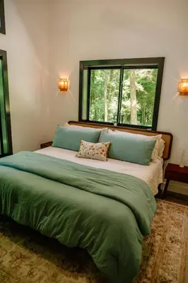a bedroom with a large green bed with a window at Lotus in Loudonville