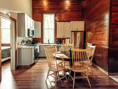 a kitchen with a table and chairs in it at Corton Lodge on the Elk River - Riverview Suite